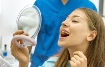 Young Girl Looking at Her Smile in a Small Mirror