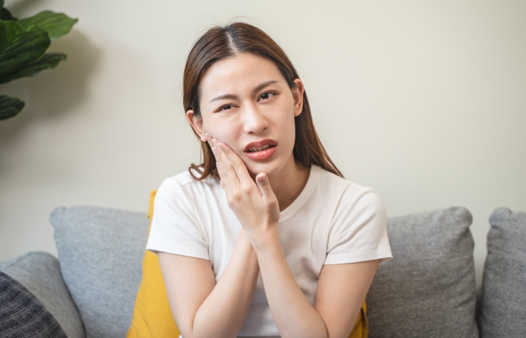 Face expression suffering from sensitive teeth, Asian young woman touching cheek, Indian Land, SC
