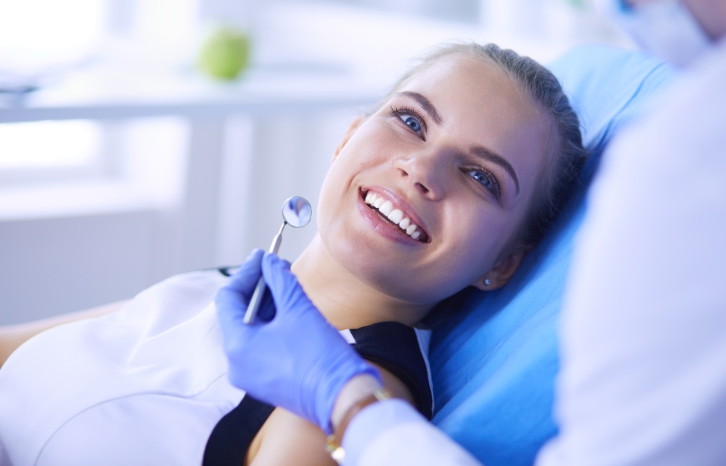 Young Female patient with pretty smile examining dental inspection at dentist office. Coronavirus COVID-19 virus pandemic, Indian Land, SC